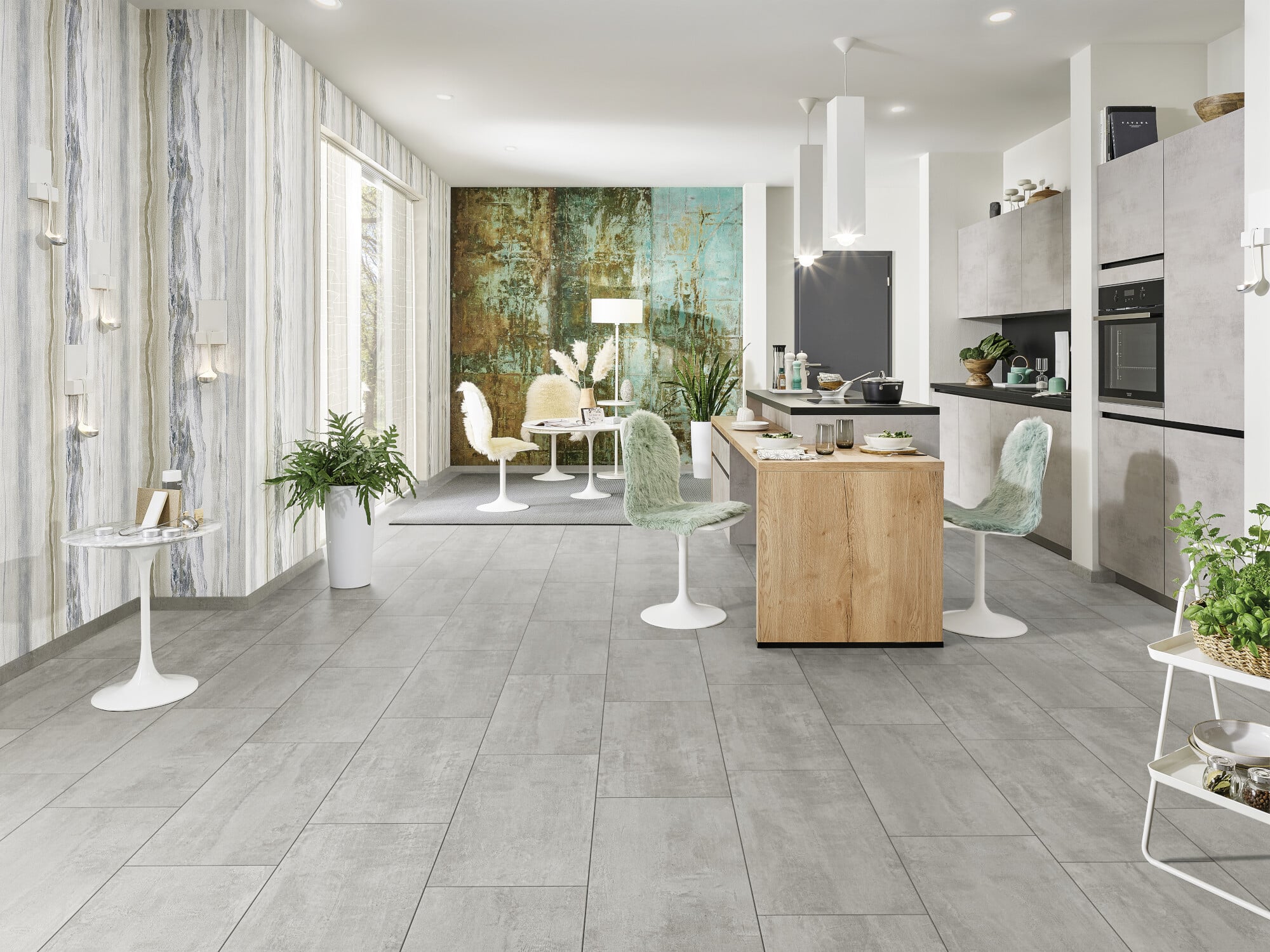 Moderne Küche mit grauem Fliesenboden, Holzinsel und hellen Wänden. Essbereich mit runden Tischen und eleganten Stühlen. Pflanzen und dekorative Elemente schaffen eine einladende Atmosphäre.
