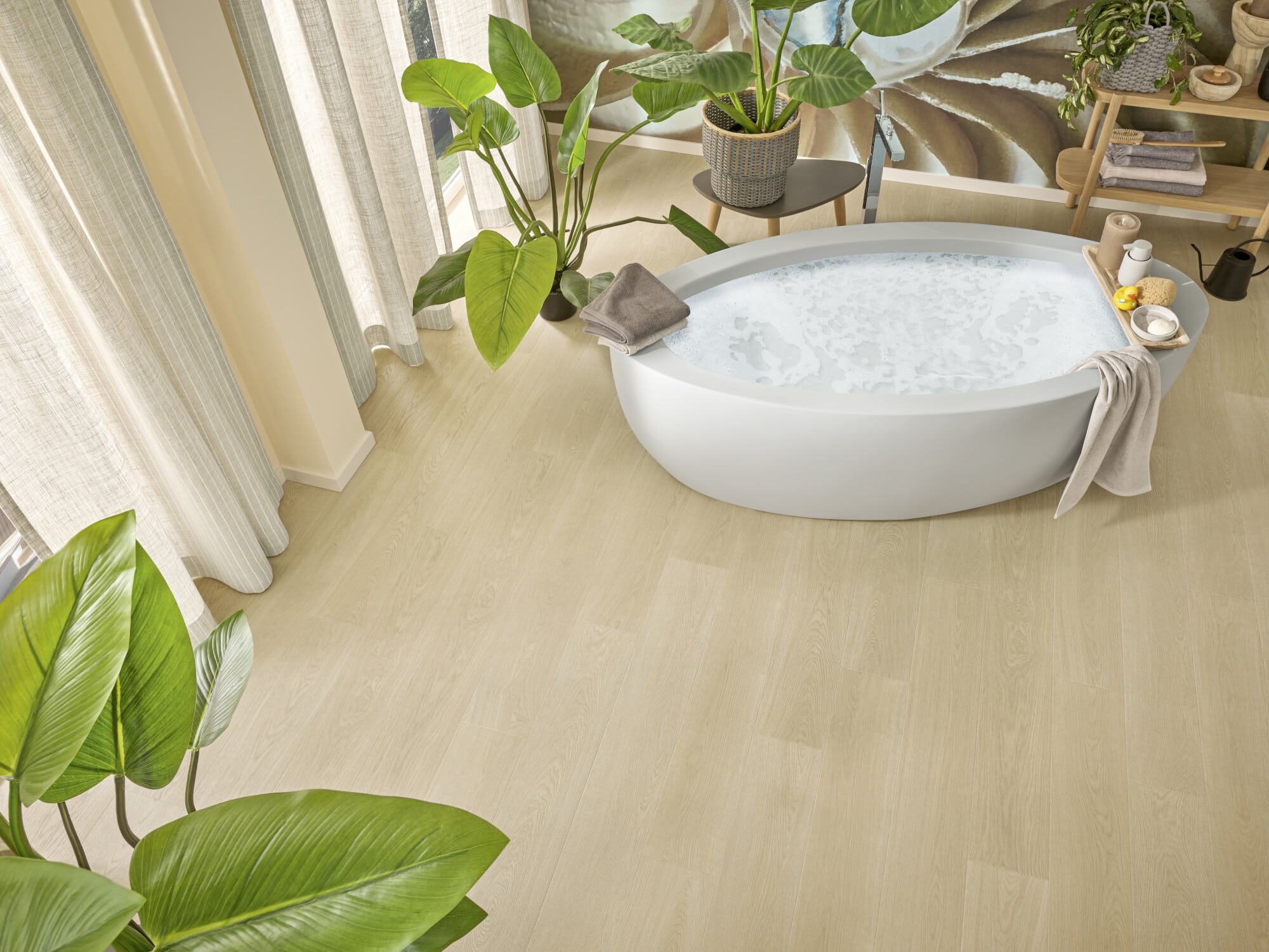 Ein modernes Badezimmer mit einer freistehenden Badewanne, umgeben von großen Pflanzen und sanften Vorhängen. Der Boden ist aus hellem Holz, und auf einem Regal sind dekorative Elemente und Pflegeprodukte platziert.