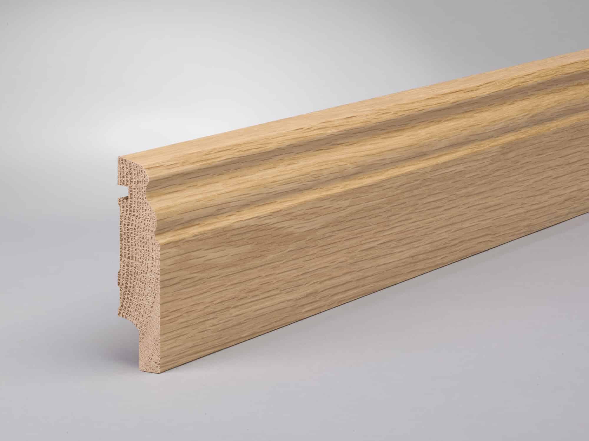 Ein Stück Holzleistenprofil mit einer dekorativen Kante, aus hellem Holz gefertigt, das auf einem grauen Hintergrund präsentiert wird.