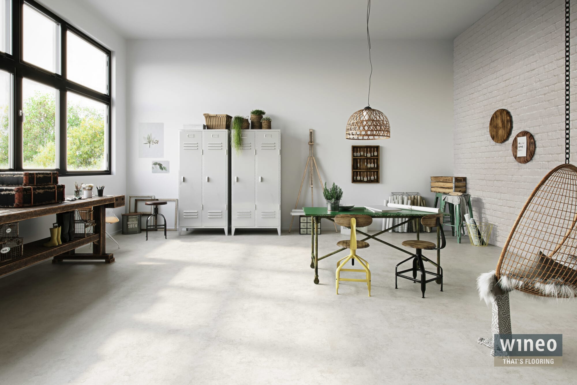 Heller, moderner Raum mit großen Fenstern, einem Holztisch, verschiedenen Stühlen, einem weißen Schrank, Pflanzen und dekorativen Elementen an den Wänden. Eine geflochtene Lampe hängt von der Decke und sorgt für eine gemütliche Atmosphäre.
